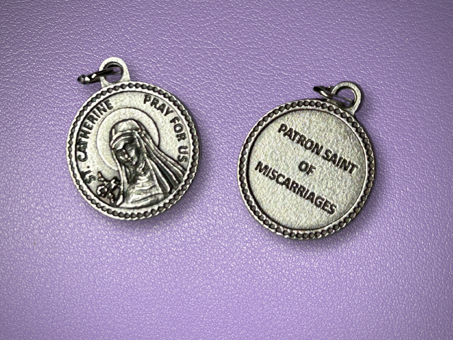 Silver religious pendant on a purple background