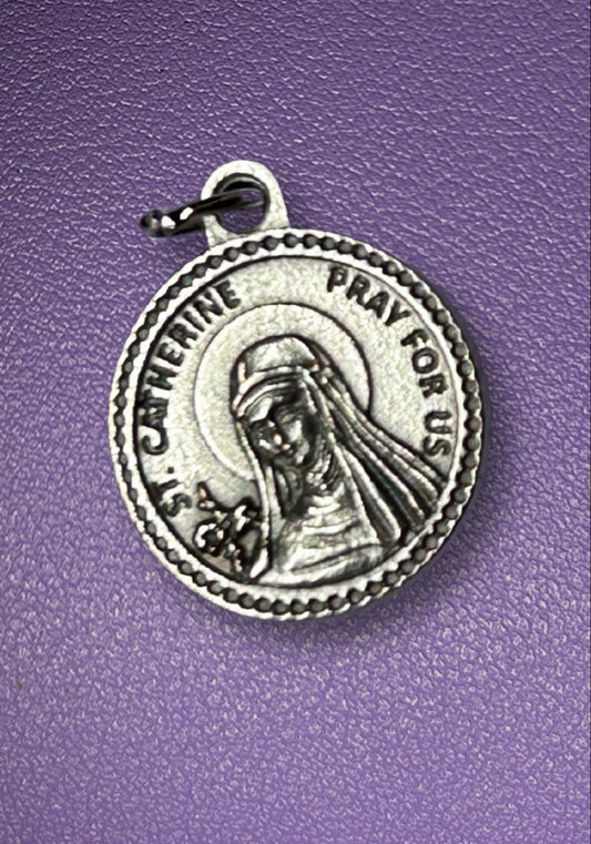 Silver religious pendant with text on a purple background