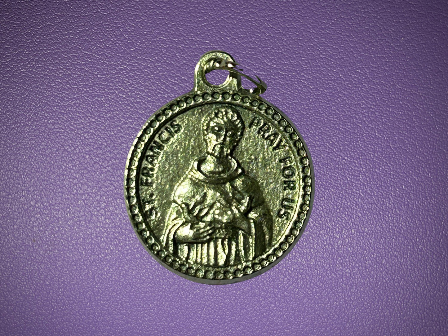 Medal with a religious figure on a purple background