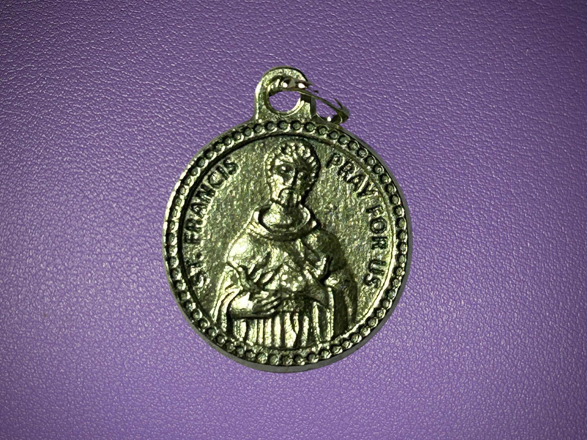 Medal with a religious figure on a purple background