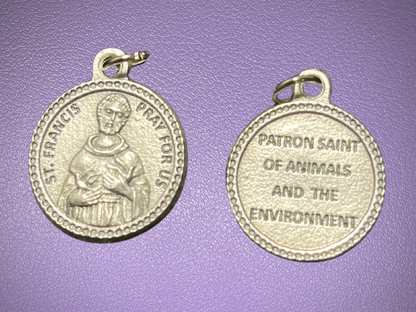 Two silver medals with engravings on a purple background